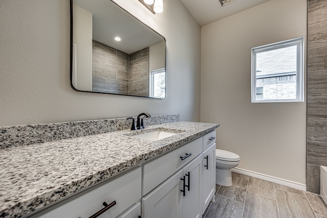 bathroom with wood-type flooring, vanity, and toilet