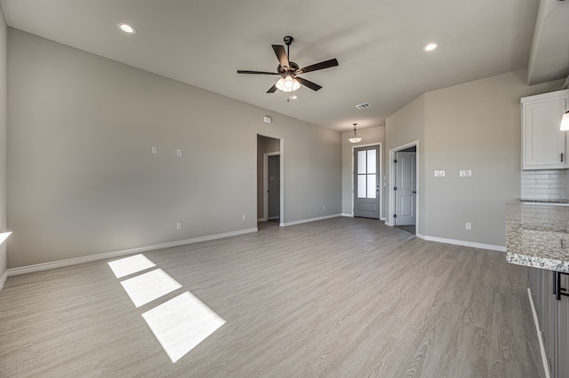 unfurnished living room featuring ceiling fan and light hardwood / wood-style floors