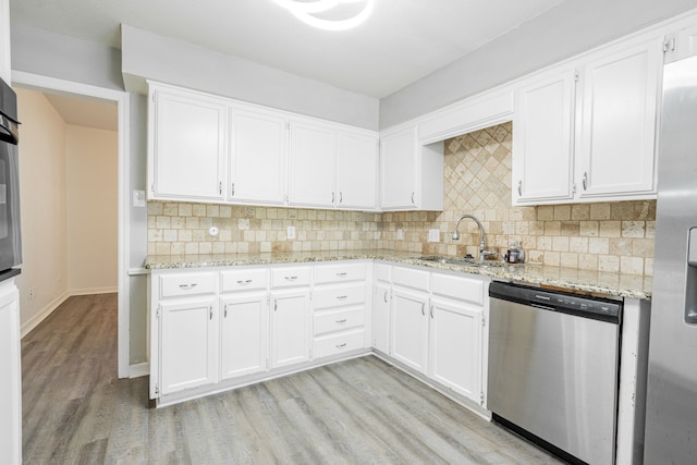 kitchen featuring stainless steel appliances, tasteful backsplash, sink, light hardwood / wood-style floors, and white cabinetry