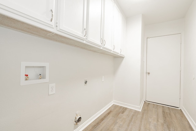 laundry area featuring electric dryer hookup, hookup for a washing machine, light hardwood / wood-style flooring, and cabinets