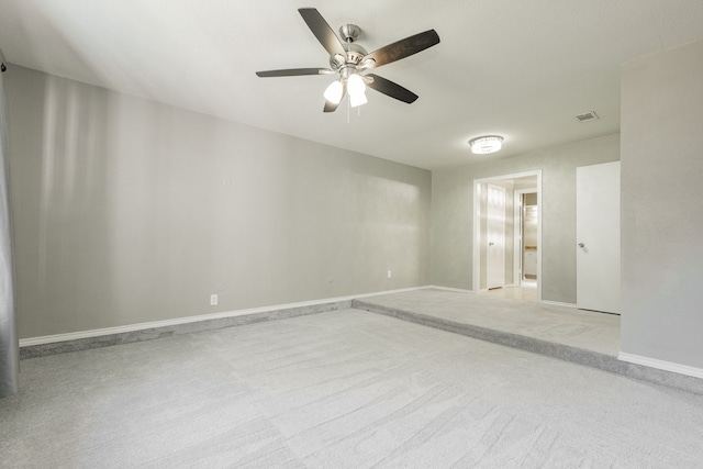 carpeted spare room with ceiling fan