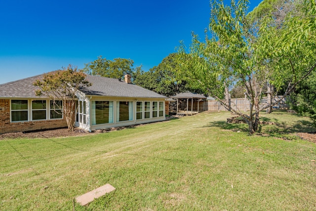 back of house with a yard and a sunroom