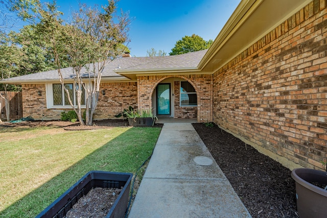 view of exterior entry featuring a yard