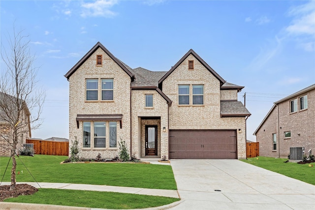 view of front of home featuring central AC, a garage, and a front yard