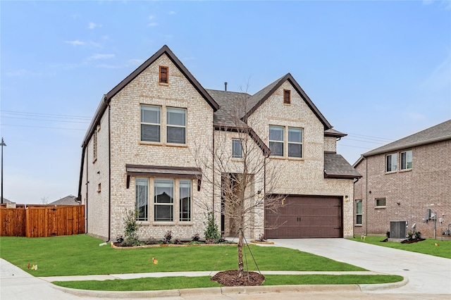 view of front of property featuring a garage, central AC, and a front lawn