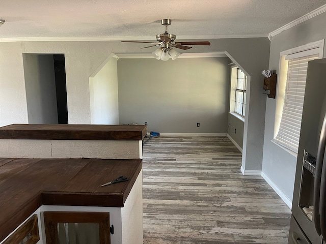 interior space featuring crown molding, hardwood / wood-style floors, a textured ceiling, and ceiling fan