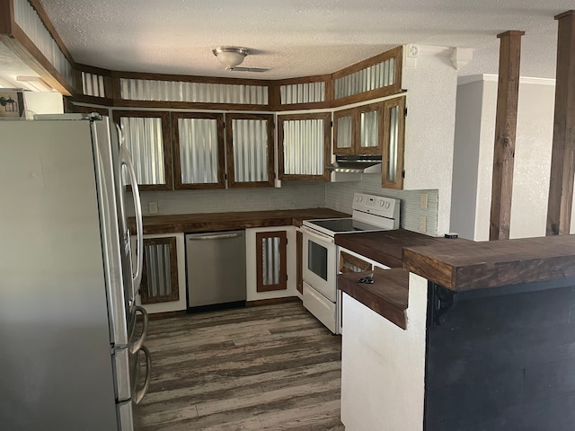 kitchen featuring appliances with stainless steel finishes, kitchen peninsula, dark wood-type flooring, and a textured ceiling