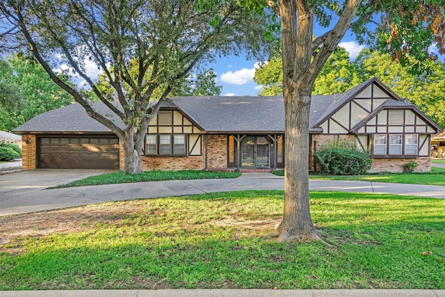 english style home with a garage and a front lawn