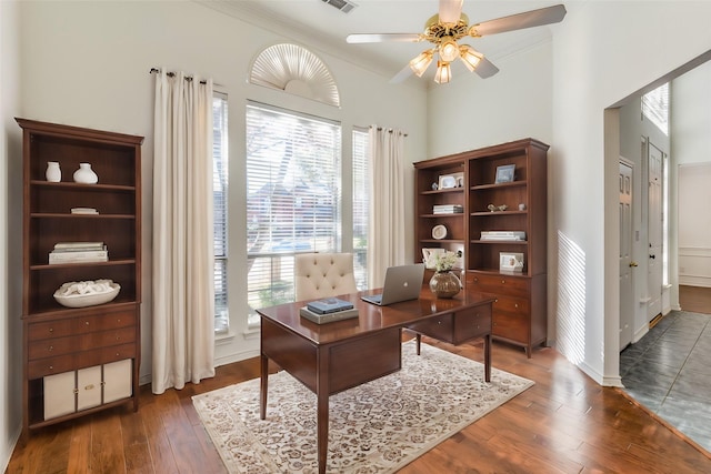 home office featuring ceiling fan, dark wood-type flooring, and ornamental molding