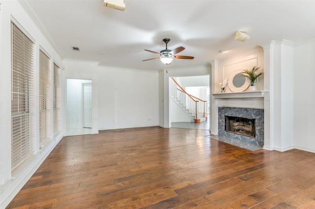 unfurnished living room featuring a premium fireplace, ceiling fan, dark wood-type flooring, and ornamental molding