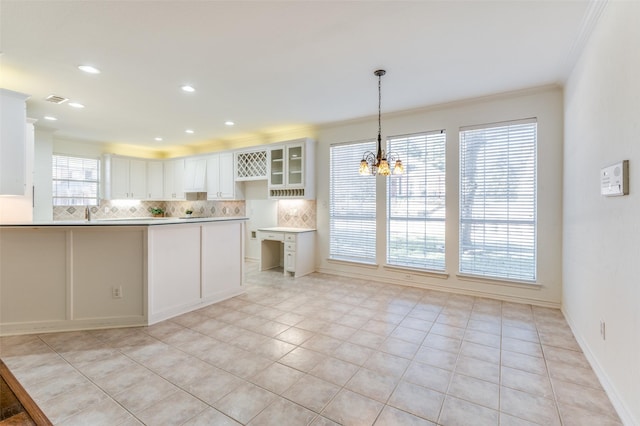 kitchen featuring tasteful backsplash, light tile patterned floors, an inviting chandelier, white cabinets, and hanging light fixtures