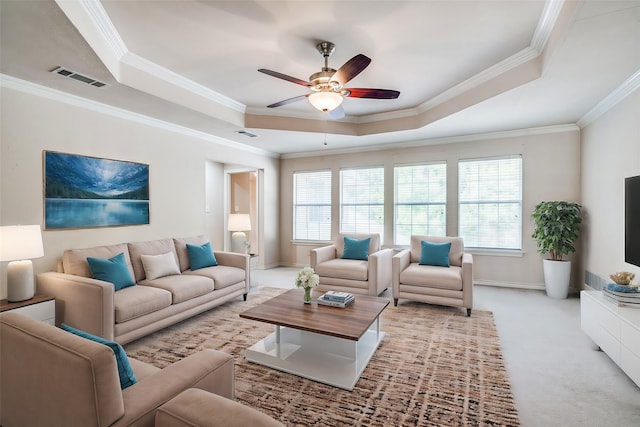 carpeted living room featuring a tray ceiling, a wealth of natural light, and ornamental molding