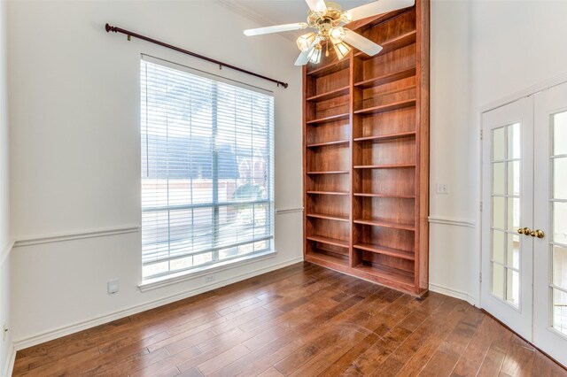 unfurnished room featuring ceiling fan, dark hardwood / wood-style floors, built in shelves, and french doors