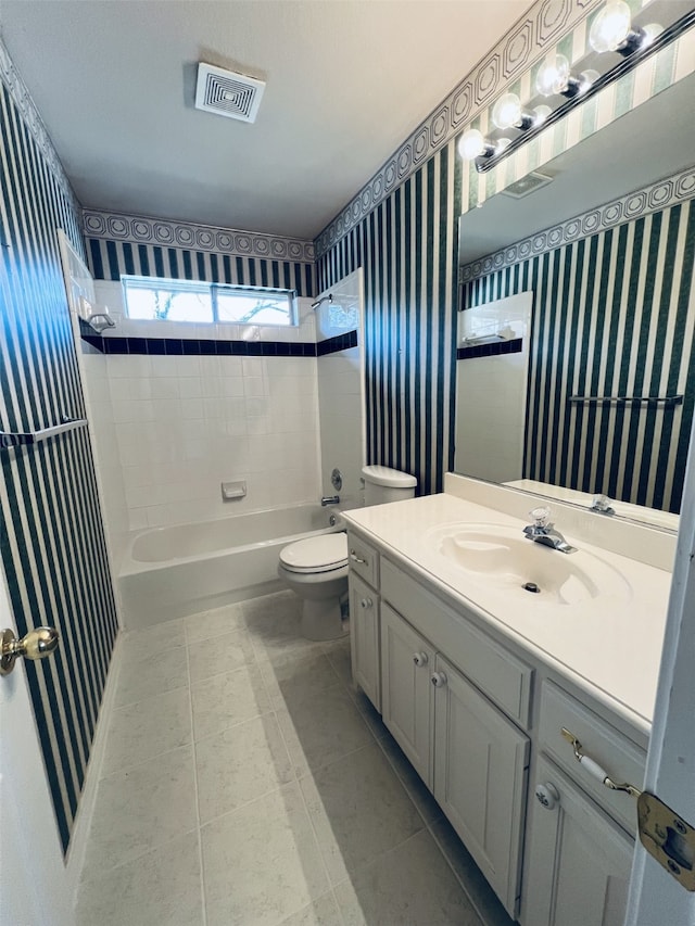 full bathroom featuring tile patterned floors, vanity, toilet, and tiled shower / bath