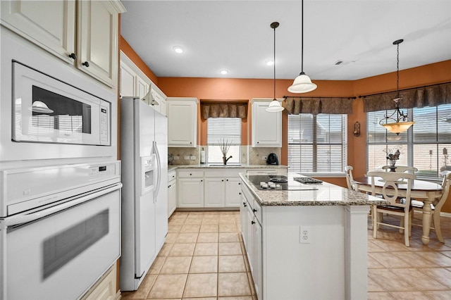 kitchen with white cabinetry, a center island, white appliances, and decorative light fixtures