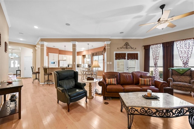 living room featuring ornate columns, ceiling fan, ornamental molding, and light hardwood / wood-style floors