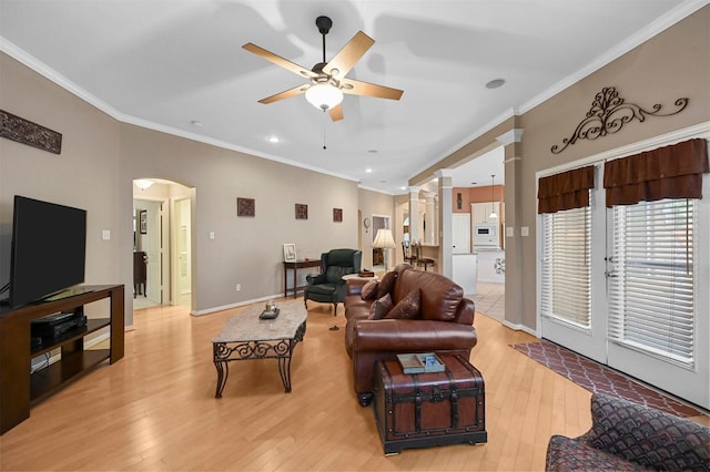 living room featuring crown molding, ornate columns, ceiling fan, and light wood-type flooring