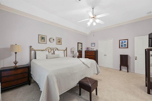 bedroom featuring ornamental molding, light carpet, ceiling fan, and a closet