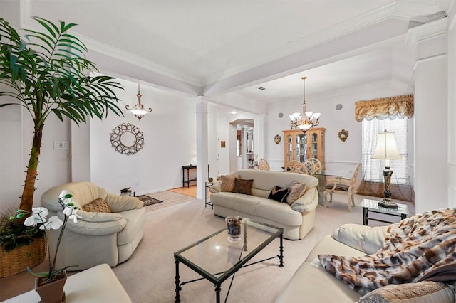 living room featuring a notable chandelier, crown molding, and decorative columns