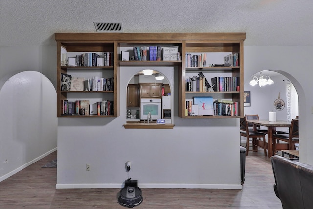 room details with wood-type flooring, a textured ceiling, and oven