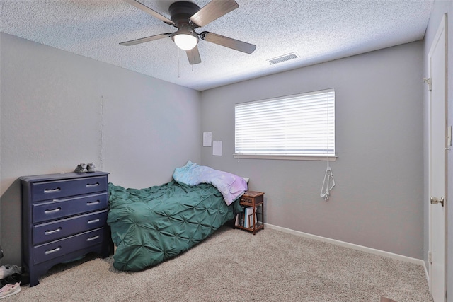 carpeted bedroom with a textured ceiling and ceiling fan