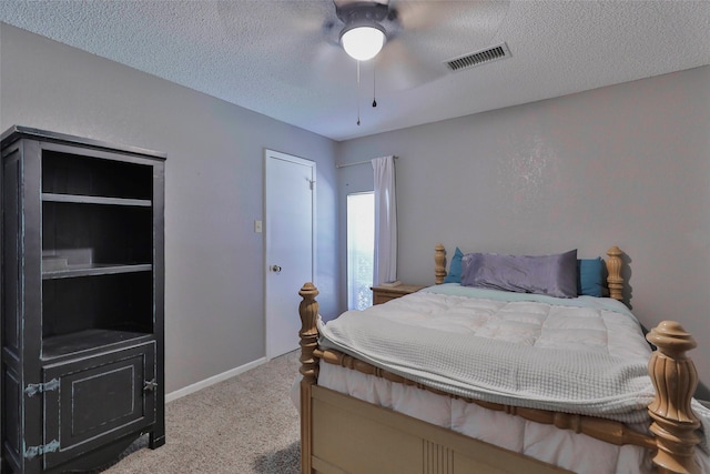 carpeted bedroom with ceiling fan and a textured ceiling