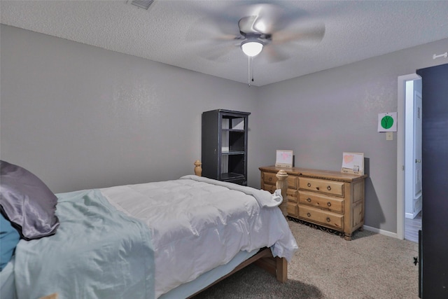 bedroom featuring ceiling fan, light colored carpet, and a textured ceiling