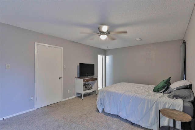 carpeted bedroom featuring a textured ceiling and ceiling fan