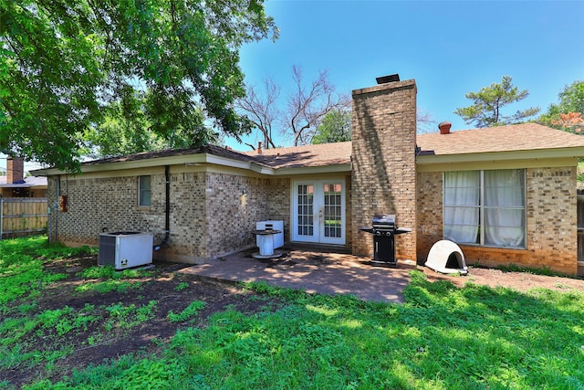 back of house with a lawn, a patio area, and central AC