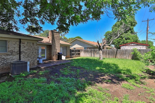 view of yard with central air condition unit and a patio