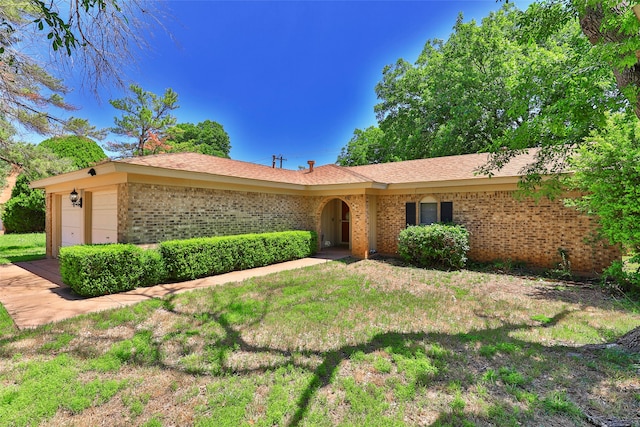 single story home featuring a garage and a front lawn