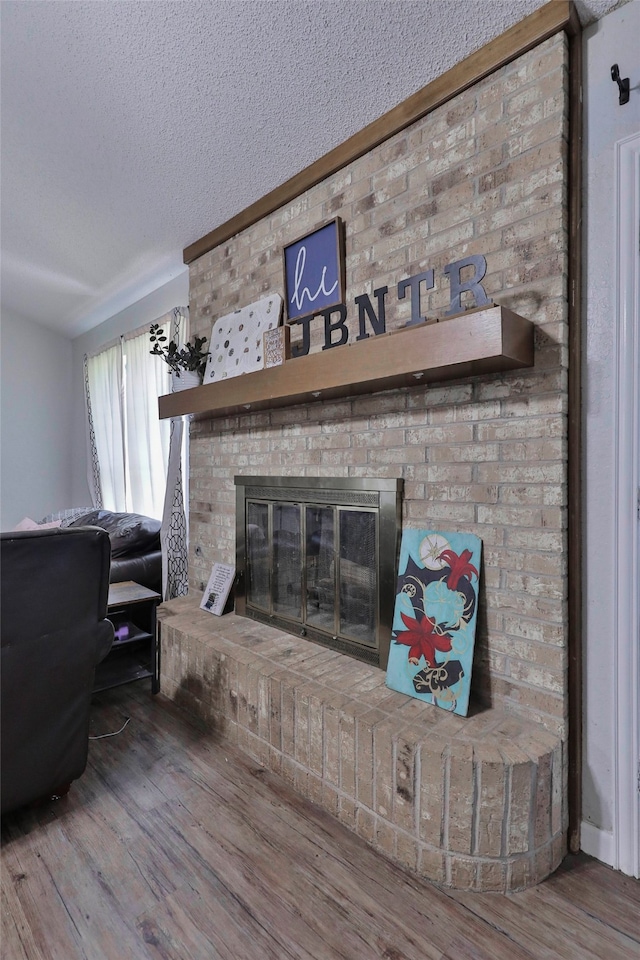 room details featuring a fireplace, wood-type flooring, and a textured ceiling