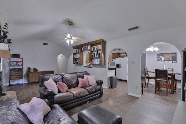 living room featuring wood-type flooring, lofted ceiling, and ceiling fan