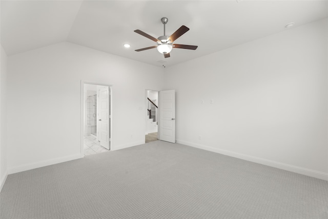 empty room featuring vaulted ceiling, light colored carpet, and ceiling fan