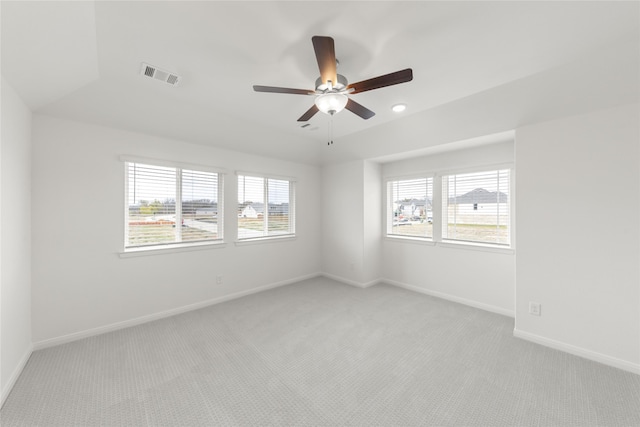 carpeted spare room with a wealth of natural light and ceiling fan