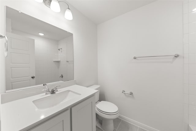 bathroom featuring tiled shower, tile patterned floors, toilet, and vanity