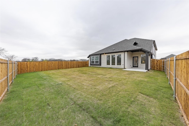 rear view of house with a patio and a lawn