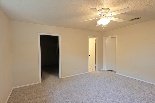 carpeted empty room with a textured ceiling and ceiling fan