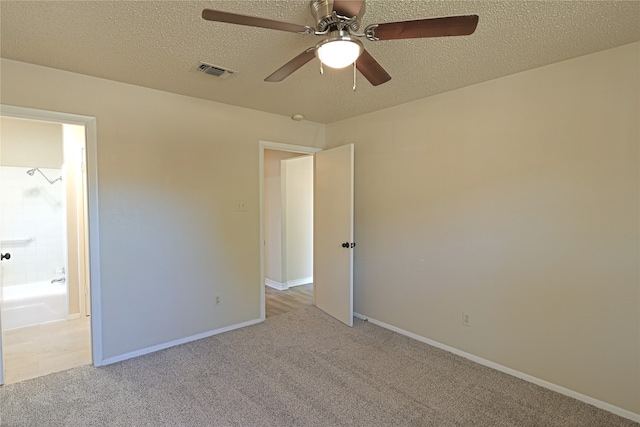 unfurnished bedroom with light carpet, ceiling fan, and a textured ceiling