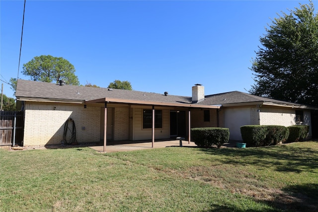 rear view of property with a lawn and a patio