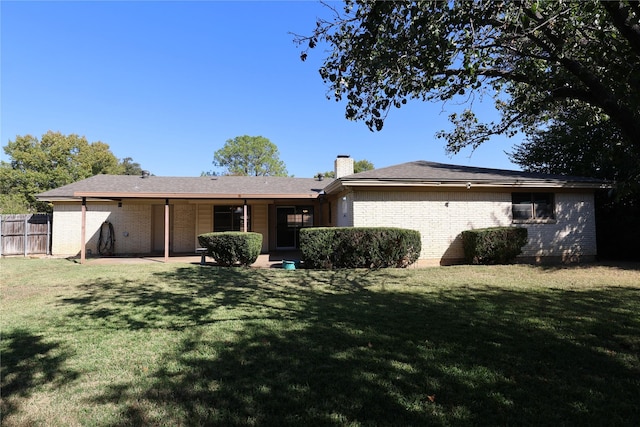 back of house with a lawn and a patio area