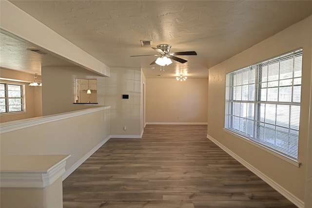 unfurnished room featuring ceiling fan, dark wood-type flooring, and a textured ceiling