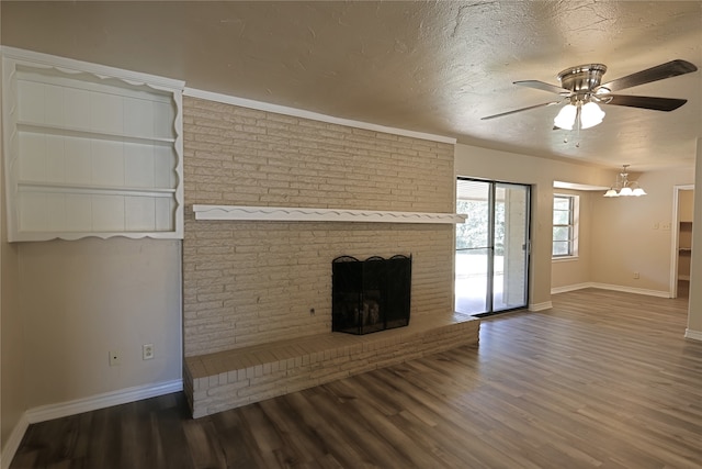 unfurnished living room featuring a textured ceiling, ceiling fan with notable chandelier, a fireplace, and hardwood / wood-style floors