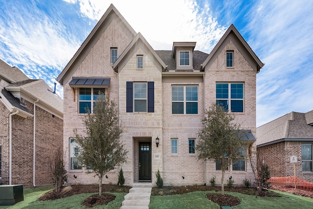 view of front of property featuring stone siding, a front yard, and brick siding