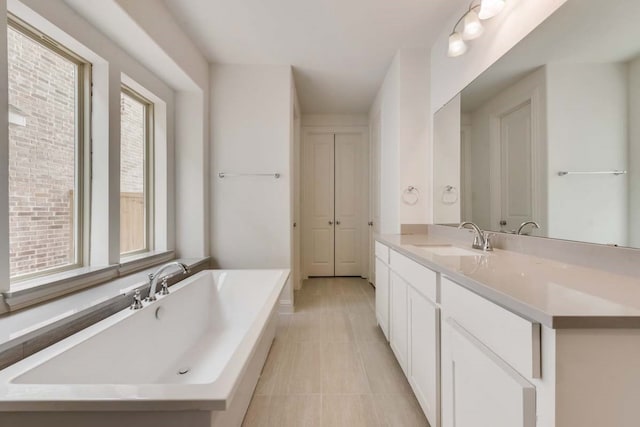 bathroom with a bathing tub, tile patterned floors, and vanity