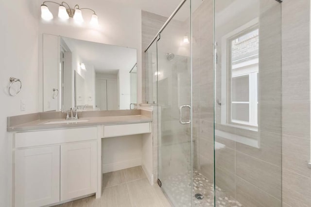 bathroom with a shower with shower door, vanity, and tile patterned floors