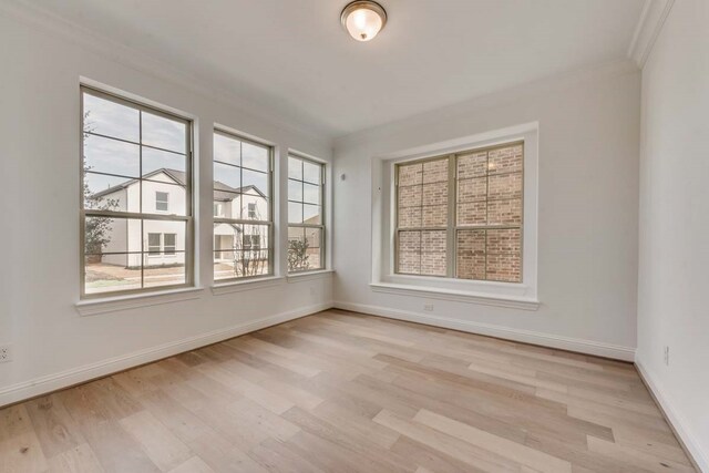 unfurnished room with light wood-type flooring and ornamental molding