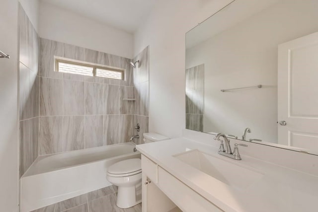 full bathroom featuring tiled shower / bath combo, vanity, and toilet