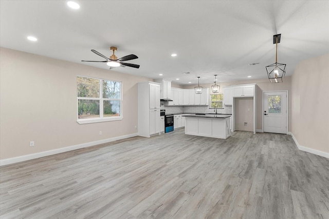 kitchen featuring pendant lighting, a center island, and white cabinetry