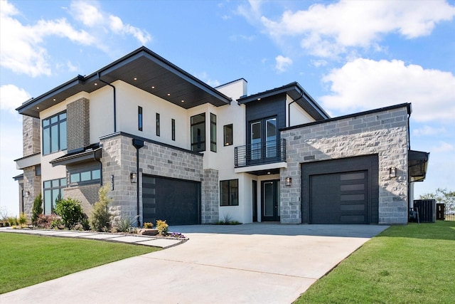 modern home with stucco siding, concrete driveway, a front yard, a balcony, and stone siding